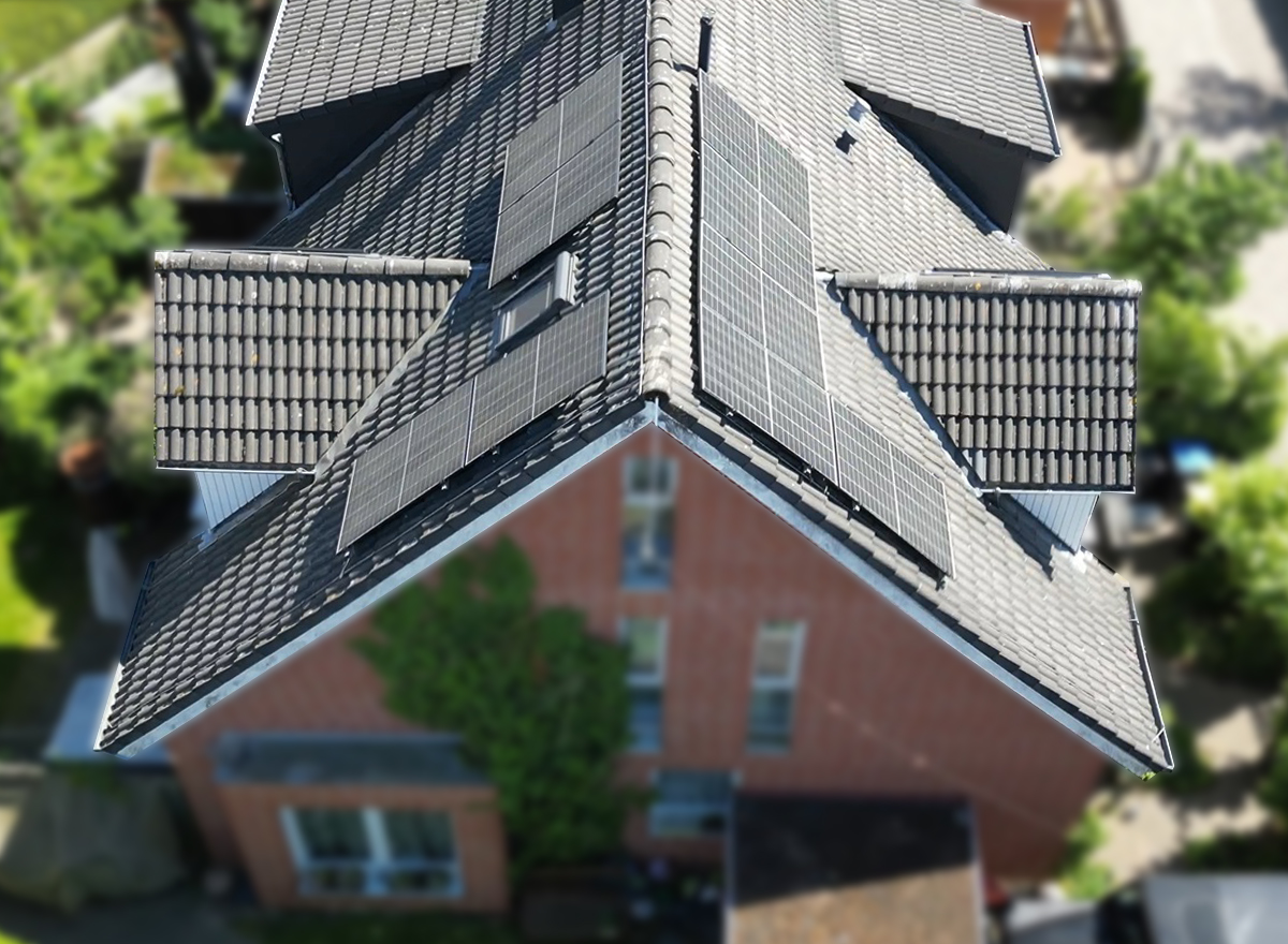 Aus der Vogelperspektive: Spitzdach eines Einfamilienhauses, auf dem eine Solaranlage installiert ist.