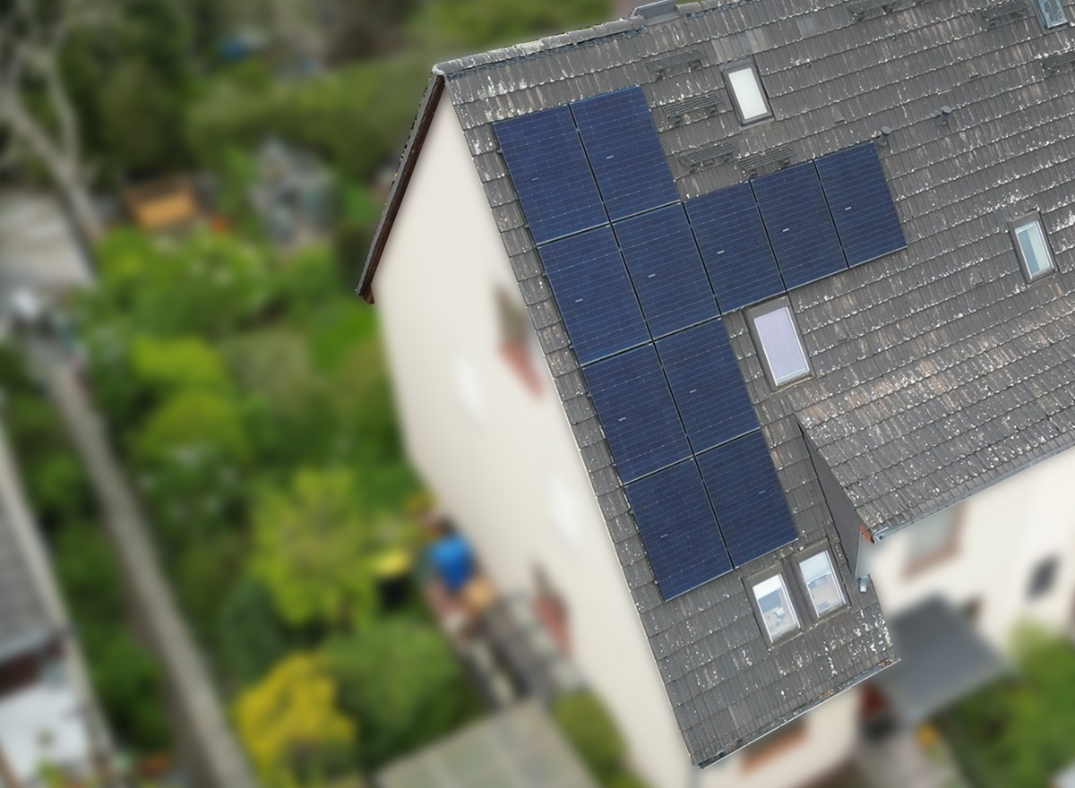 Spitzdach eines Mehrfamilienhauses mit Solaranlage aus der Luft aufgenommen